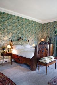 a bedroom with a large bed and a wall with wallpaper at Rossnaree House in Slane