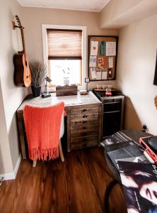 a kitchen with a desk and a sink and a guitar at The Loft in Granville