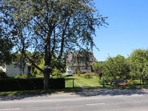 a tree in front of a house with a driveway at Cozy Summer House with Free Parking near Town Center & Beach in Kuressaare +20 photos