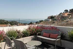 a balcony with a chair and a table and some flowers at Alta House Begur in Begur