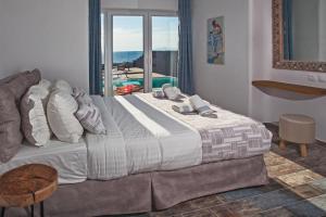 イメロヴィグリにあるアベロマイロス エクスクルーシブ ヴィラの海の景色を望むベッドルーム1室(大型ベッド1台付)