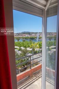 a room with a view of the water from a window at Comfort Tua in Mirandela