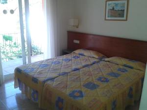 a bedroom with a bed with a quilt on it at Fonda Finet in Sant Feliu de Pallerols
