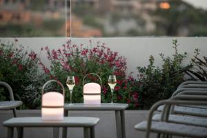 two tables with wine glasses on a patio with flowers at Alta House Begur in Begur