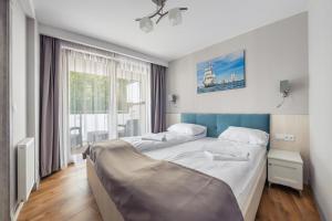 een slaapkamer met een groot bed en een raam bij Apartamenty Cypel Helski in Hel