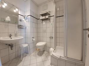 a bathroom with a toilet and a sink and a shower at Erlanger Hof in Berlin