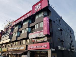 een gebouw met borden aan de zijkant bij Bloommaze Boutique Hotel Klang in Klang