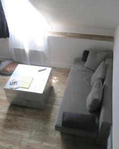 uma sala de estar com um sofá e uma mesa de centro em Studio Bastille Lappe CityCosy em Paris