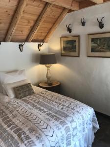 a bedroom with a bed with a lamp and pictures on the wall at The Barn in Emst