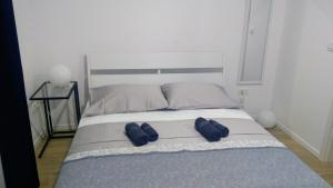 1 dormitorio con 1 cama con 2 almohadas azules en Studio apartman Adris en Šibenik