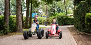 dois homens a andar em carros de brinquedo num parque em TopParken – Recreatiepark ’t Gelloo em Ede