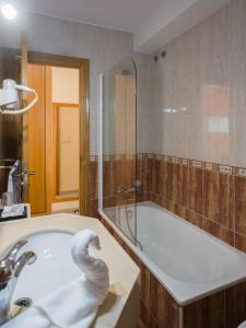 a bathroom with a bath tub and a sink at Pension Areas in O Pindo