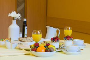 a table with a breakfast of fruit and juice at Pension Areas in O Pindo