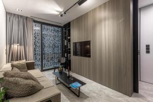 uma sala de estar com um sofá e uma televisão na parede em The Duke Boutique Suites em Atenas