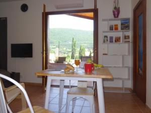 een eetkamer met een tafel en een raam bij Studio Walla Confort Centre in Montbrun-les-Bains