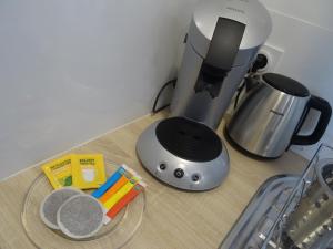 a kitchen counter with a coffee maker and a plate on a table at Studio Walla Confort Centre in Montbrun-les-Bains +2 photos