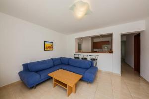a living room with a blue couch and a table at Seaview apartments in Bobovišća