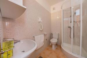 a bathroom with a tub and a toilet and a shower at Seaview apartments in Bobovišća