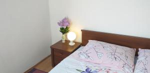 a bedroom with a bed with a vase of flowers on a table at Guesthouse Loncar in Plitvička Jezera