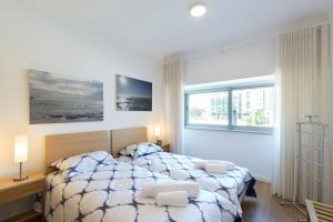 um quarto com uma cama e uma grande janela em Lovely Flat with Charming Terrace by Host Wise em Vila Nova de Gaia