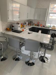 a kitchen with a counter and bar stools in it at Entire 6 Bed 5 Star Luxury House FREE WiFi nice views in Burnley