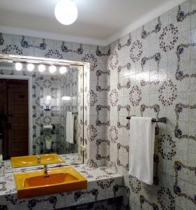 a bathroom with a yellow sink and a mirror at Famille au Cœur de Lisbonne in Lisbon