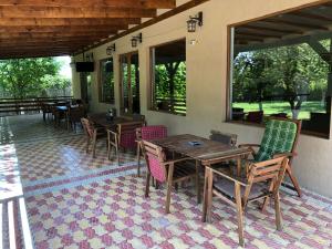 patio ze stołami, krzesłami i oknami w obiekcie Equinox Club w mieście Corbu