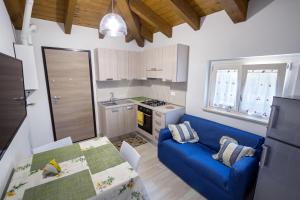 una pequeña cocina con un sofá azul y una mesa en Colibri B&B, en Lanciano