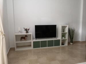 a white entertainment center with a flat screen tv at apartamento princesa Leticia in Sanlúcar de Barrameda