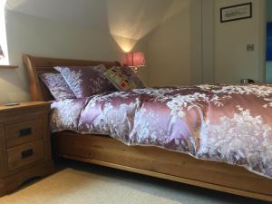 a bedroom with a bed with a wooden frame and a table at Martlets B&B in Shanklin