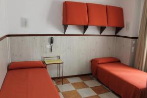 Habitación pequeña con 2 camas y teléfono en Don Paula, en Córdoba