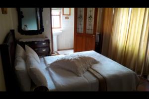 a bed with white sheets and pillows in a bedroom at MAVILLA STELLENBOSCH B&B in Stellenbosch