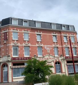 un gran edificio de ladrillo rojo con un cartel. en Hotel du Gambrinus, en Hazebrouck
