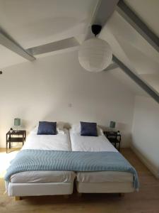 1 cama blanca con almohadas azules en una habitación en Duplex plein centre ville 10B, en Malestroit