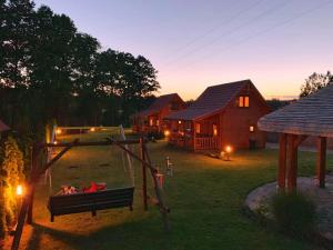 a backyard of a house with a fire in a swing at Domki u Asi in Wilkasy