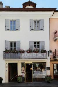 a white building with a balcony with flowers on it at Maison Alliod in Saint Vincent