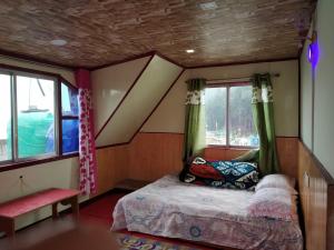 una camera con un letto in una stanza con finestre di Vamoose Kanchan Kanya a Sukhia Pokhari