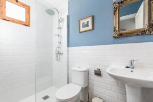 a bathroom with a toilet and a sink and a mirror at La Colina in Puebla de Vallbona