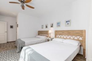 a bedroom with two beds and a ceiling fan at La Colina in Puebla de Vallbona