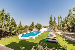 einen großen Garten mit Pool und Gras in der Unterkunft La Colina in La Pobla de Vallbona