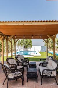 a group of chairs under a pavilion with a pool at La Colina in Puebla de Vallbona