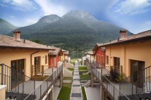 a row of houses with mountains in the background at Residence Borgo Del Cigno in Spinone Al Lago