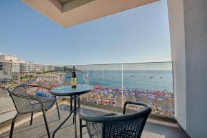 a balcony with a table and chairs and a view of the beach at Hotel Obala in Dobra Voda