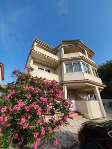 a house with pink flowers in front of it at Apartments Kim in Rab