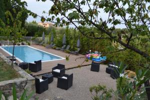 une cour avec une piscine, des chaises et une table dans l'établissement Le Jardin de Lucette, à Le Rouret