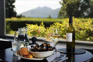 einen Tisch mit einem Teller Essen und einer Flasche Wein in der Unterkunft The Ballachulish Hotel in Glencoe