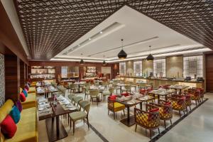 Welcomhotel by ITC Hotels, Rama International, Aurangabad في أورانغاباد: مطعم بطاولات وكراسي وبار