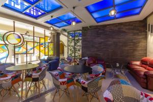 una stanza con tavoli, sedie e vetrate istoriate di Green Palace Hotel a Yerevan