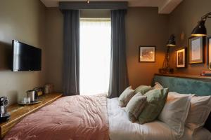 a bedroom with a bed with a large window at Broad Street Townhouse in Bath