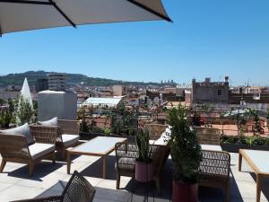 a balcony with tables and chairs and a view of a city at Silken Ramblas in Barcelona